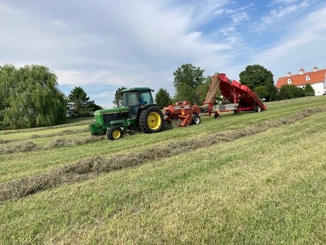 Farm tractor harvesting hay bales at Bitter Sweet Knolls
